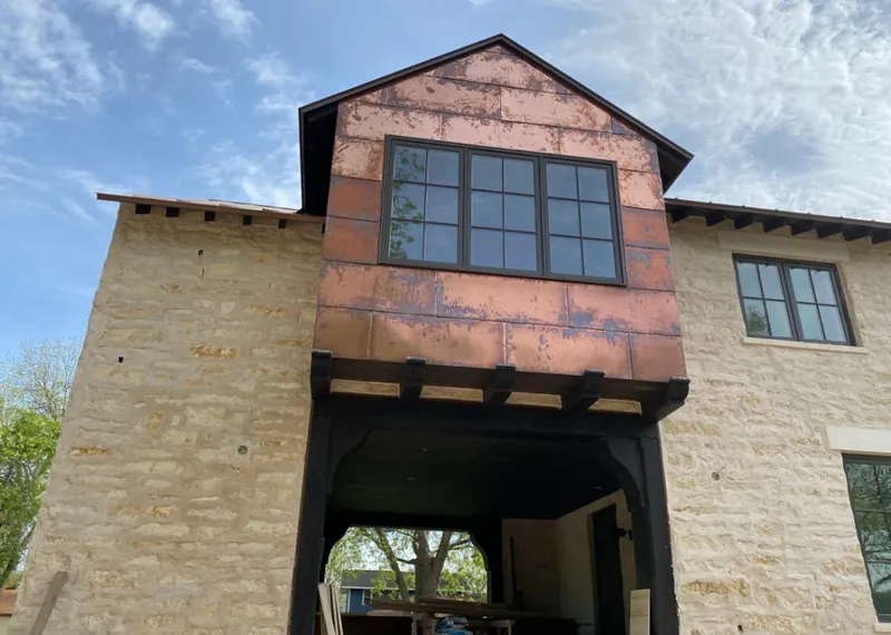 Copper metal panel facade on a stone building for Roof Repair in Lakehills